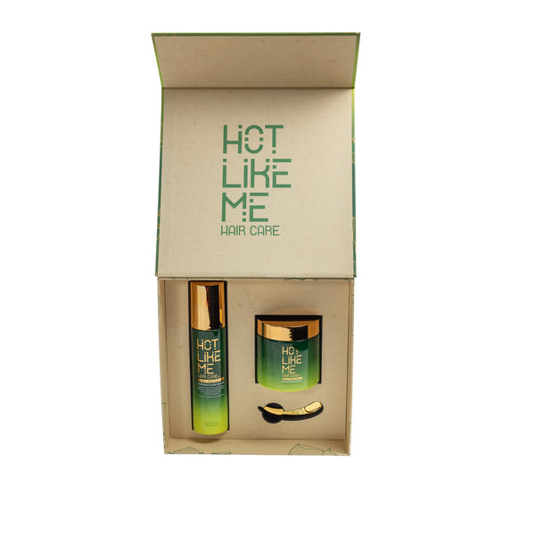 A haircare kit presented in a box with the brand name 'Hot Like Me'. The kit includes a spray bottle and a jar, both with green labels and gold accents.