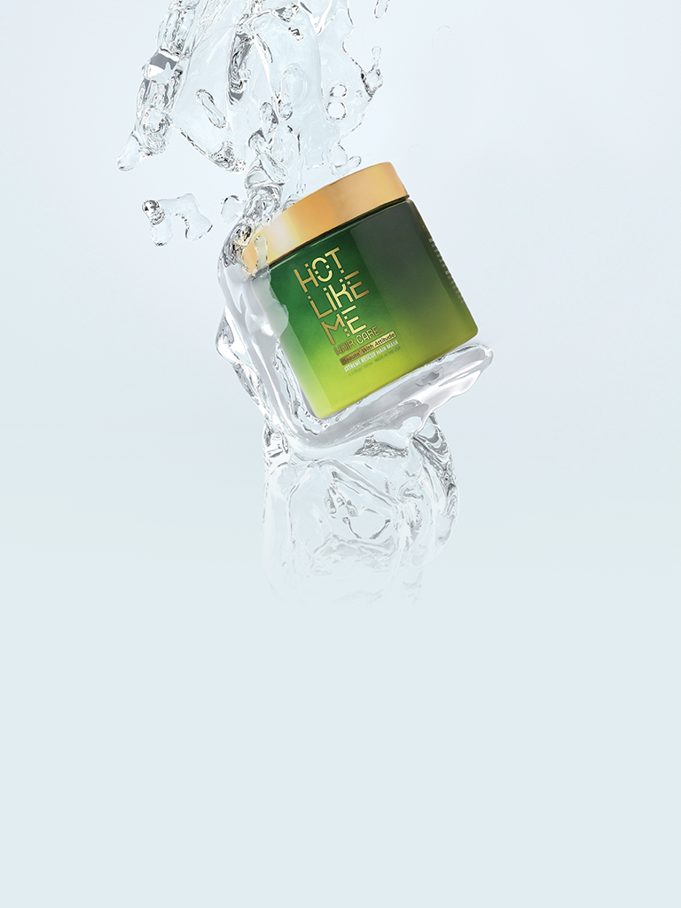 Hot Like Me Haircare Extreme Rescue Mask Bottle, being held up by a splash of refreshingly cool water. 